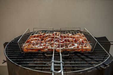 Barbeküde ızgara yapan taze karidesler, kızgın kömürlerin üzerinde metalik bir ızgarada dinlenen, mis kokulu dumanlar saçan ve havayı ağız sulandıran bir aromayla dolduran, yaz toplantıları için mükemmel bir yer.