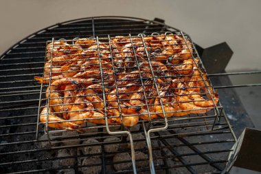 Izgarada ızgara yapan taze karidesler ağız sulandıran bir yaz yemeği yaratır, havayı lezzetli dumanlı bir aromayla doldurur ve açık hava yemek deneyimlerini arttıran cazip tatlar sunar.