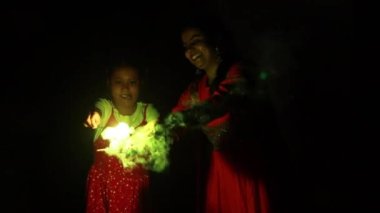 Hintli kız ve annesi diwali festivali sırasında havai fişeklerin keyfini çıkarıyorlar.