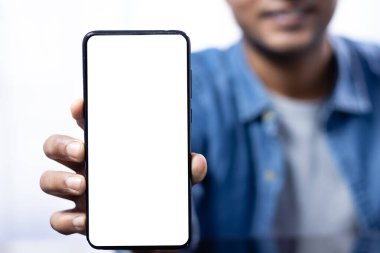 Elinde gülümseyen Hintli bir erkek tarafından tutulan beyaz, boş, akıllı bir telefon ekranını kapat.