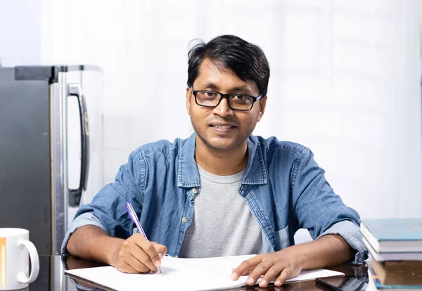一名印度年轻男子在家里学习时 面带微笑地看着相机 背景是白色的 — 图库照片