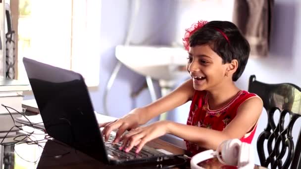 一个穿着红色衣服的印度可爱女孩在家里用笔记本电脑玩电子游戏 — 图库视频影像