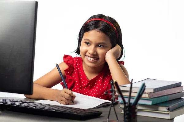 一个漂亮的印度女孩在白底桌旁用台式计算机学习 — 图库照片