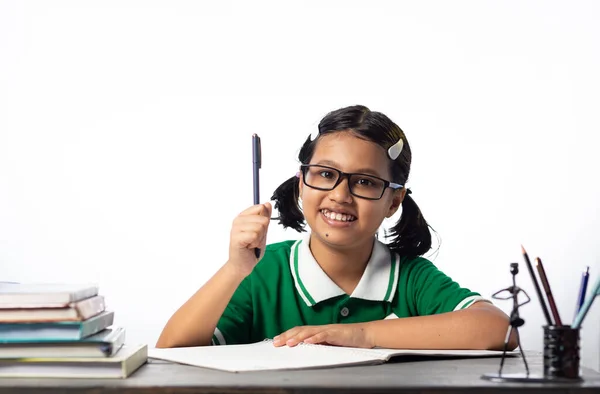 美しいですインドの女の子の子供で眼鏡をかけて勉強テーブルの上に白い背景 — ストック写真