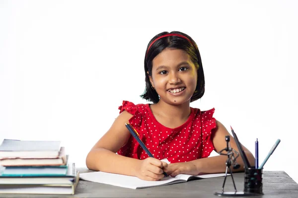かなり美しいですインドの女の子勉強テーブルで本とともに白い背景 — ストック写真