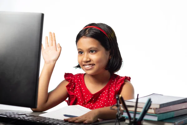 一个漂亮的印度女孩在白种人背景的桌面上用台式计算机参加在线课程 — 图库照片