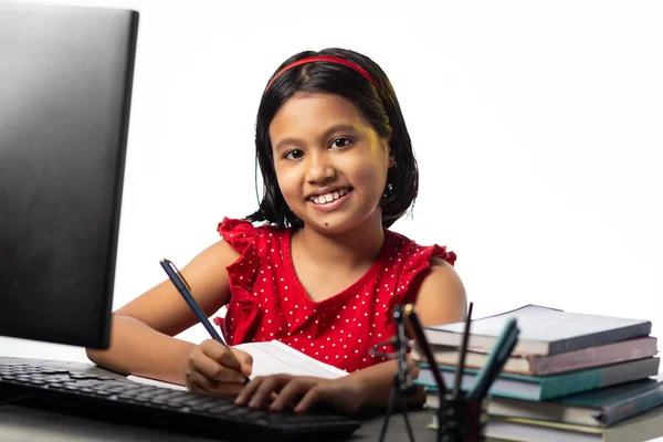 白い背景の研究テーブルでデスクトップコンピュータで勉強かなり美しいインドの女の子 — ストック写真