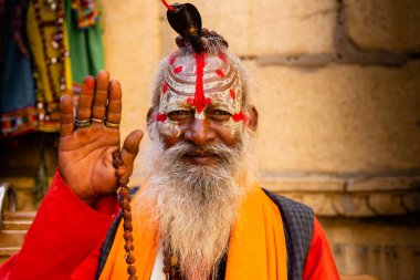 Jaisalmer, Rajasthan, Hindistan - 30 Ekim 2023: Kameraya bakarak kutsayan geleneksel dini kıyafet giymiş Hindu bir keşişin portresi