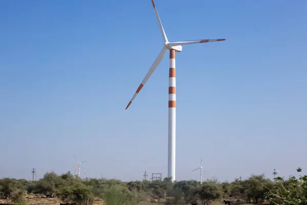 stock image Number of wind mills painted in red and white standing on clear blue sky background to generate electric power