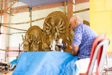 Birbhum, Batı Bengal, Hindistan - 14 Ekim 2023: Puja festivalinden önce bir terzi pandal giysileri dikiyor