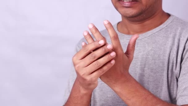 指の痛みに苦しむインド人の男性は 白い背景に痛みを伴う表現を示しています — ストック動画