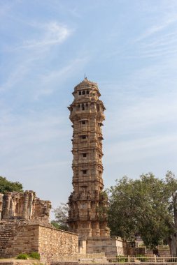 Chittorgarh, Rajasthan, India - November 4th 2023: The famous victory stand or vijaya stambha of Chittorgarh Fort standing high on clear blue sky clipart