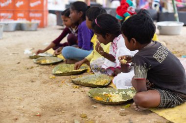 Birbhum, Batı Bengal, Hindistan - 26 Şubat 2024: Gündüz vakti yemek yiyen bir grup Hintli köy çocuğu