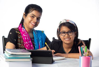 Hintli bir kız öğrenci annesinin yanında tabletle çalışıyor, öğretmen: özel öğretmen konsepti