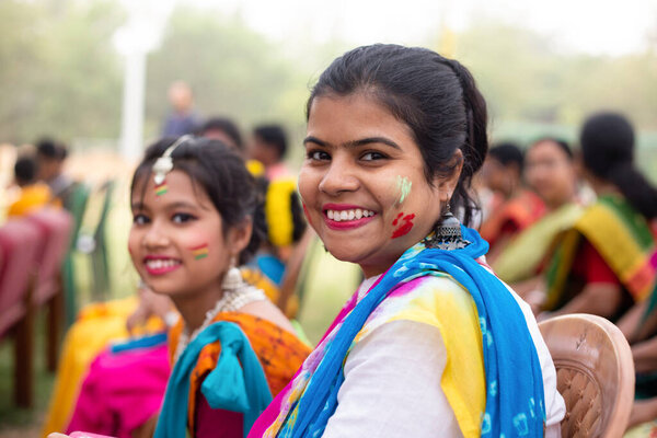 Indian mother and daughter in colorful faces during Holi