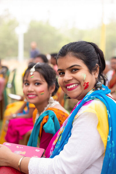 Indian mother and daughter in colorful faces during Holi