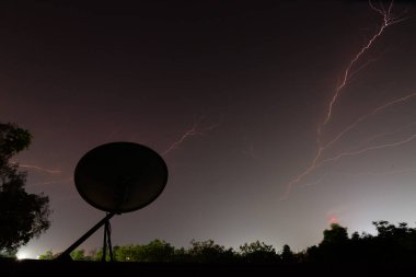 Fırtınalı bir havada büyük bir gök gürültüsü ve şimşekle gece gökyüzü manzarası