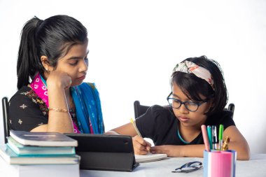 Hintli bir kız öğrenci annesinin yanında tabletle çalışıyor, öğretmen: özel öğretmen konsepti
