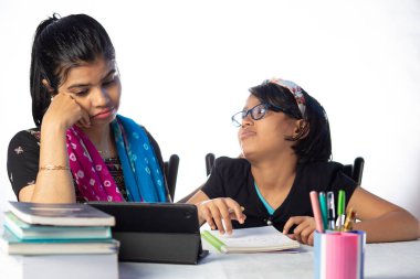 Hintli bir kız öğrenci annesinin yanında tabletle çalışıyor, öğretmen: özel öğretmen konsepti