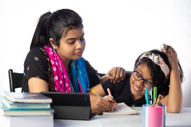 Hintli bir kız öğrenci annesinin yanında tabletle çalışıyor, öğretmen: özel öğretmen konsepti