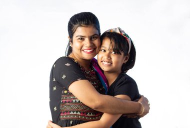 Hintli anne ve çocuk kucaklaşıyorlar. Beyaz arka planda gülümseyerek sarılıyorlar.