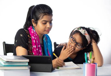 Hintli bir kız öğrenci annesinin yanında tabletle çalışıyor, öğretmen: özel öğretmen konsepti