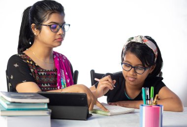 Hintli bir kız öğrenci annesinin yanında tabletle çalışıyor, öğretmen: özel öğretmen konsepti