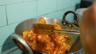 Hint baharatlı tavuk körisi gaz fırınında alüminyum bir çatalla pişiriliyor.