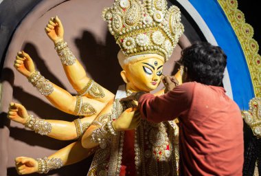 Birbhum, Batı Bengal, Hindistan - 14 Ekim 2023: Puja festivalinden önce bir sanatçı Durga putunun gözlerini boyuyor