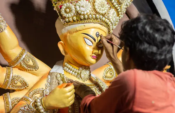 stock image Birbhum, West Bengal, India - October 14th 2023: An artist is painting the eyes of idol Durga before the puja festival