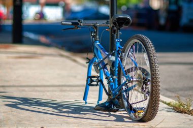 Bisikletin arka manzarası kaldırımdaki direkte kilitlidir. Ön tekerlek hırsızdan çalınmış..