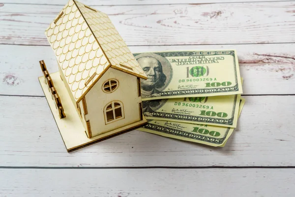 stock image Miniature wooden house surrounded by dollar notes. Savings concept for the purchase of a house. Rising mortgage interest rates