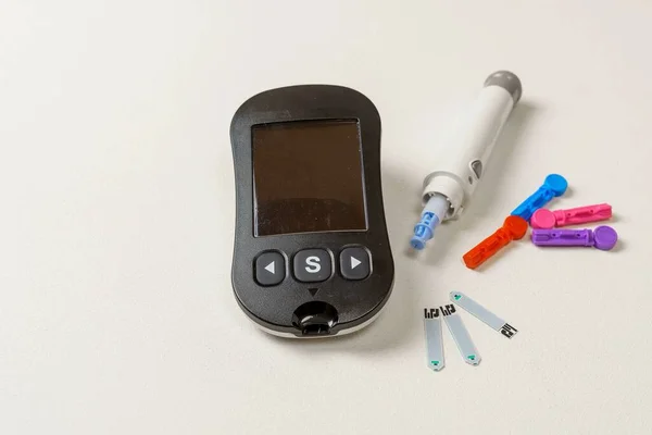 Diabetes treatment kit with digital blood glucose meter, lancets, lancing device on white background