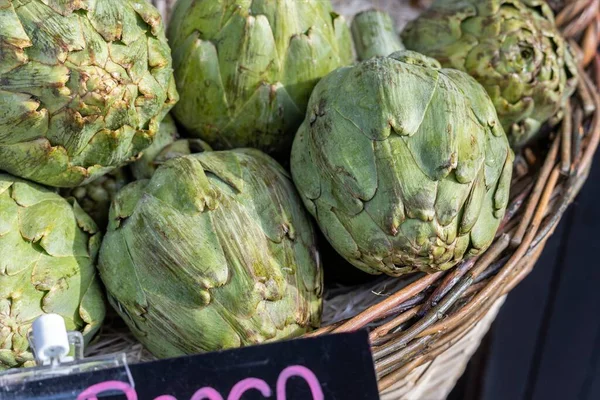 Artichokes in a basket for sale in an organic shop. Healthy and wholesome food. Responsible consumption with the planet
