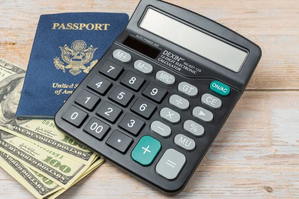 USA passport and 100 dollar notes. Top wiew. Copy space. Concept of recreational and business travel. Calculator to calculate the price of your trip