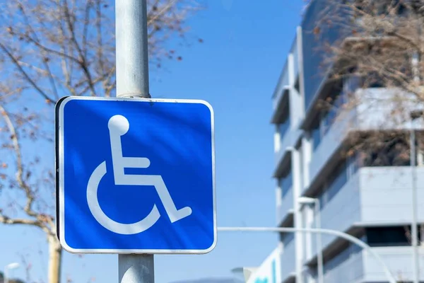 A bright blue sign for a car park with disabled access written in white, highlighting the importance of taking into account different abilities.