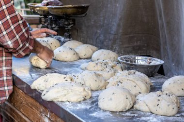 Fırında pişirmek için hazırlanmış ekmek hamuruyla çevrili bir fırıncı..