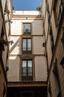 Barselona, İspanya-24 Nisan 2023. Barcelona 'nın Gotik Mahallesi' ndeki parlak renkli dar bir sokak, Gotik mimarinin giderek küçülen perspektifini gözler önüne seriyor..
