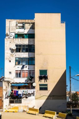 Şehrin dezavantajlı bir bölgesindeki harap bir bina. Kıyafetler dışarıda asılı. Artan konut ve kira fiyatları nedeniyle yoksulluk.