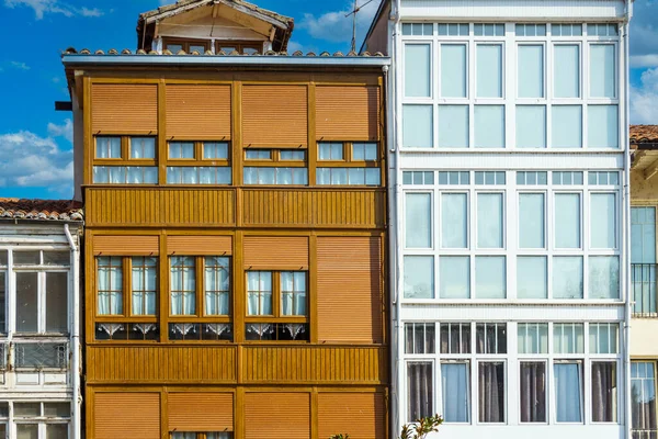 stock image Architecture, exterior of building, house with wooden windows on a background of blue sky with clouds.