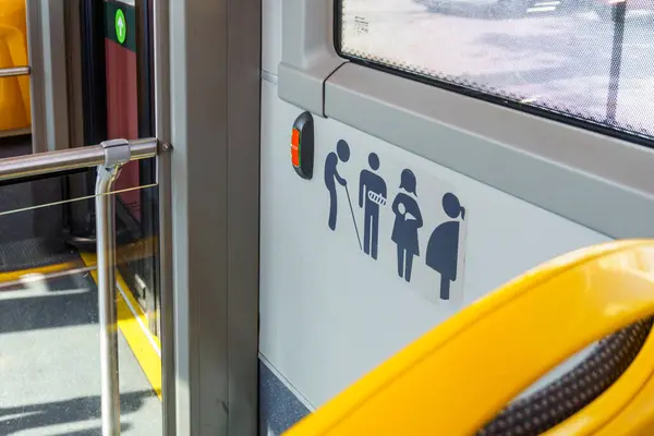 Promoting Inclusive Urban Mobility: A Detailed View of Priority Seating Icons in a City Bus Ensuring Accessibility and Courtesy for All