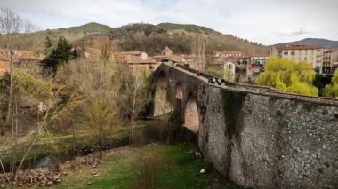 Arka planda köprüsü ve nehri olan bir köprünün dikey görüntüsü. San Joan de les abadesses, İspanya