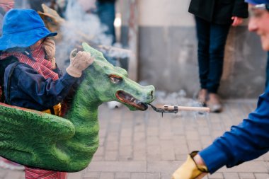 Şenlikli bir sokak etkinliğinde elinde ejderhayla şövalye gibi giyinmiş genç bir adam. Badalona, İspanya 'da Çocuk Correfoc