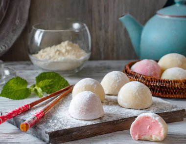 Geleneksel yemek pişirme ortamında, yumuşak dokusunu ve kremsi dokusunu vurgulayan, un tozuyla kaplı bir Japon mochi dizisi.