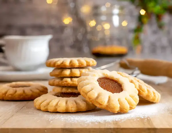 stock image A rustic culinary composition highlighting traditional Linzer cookies filled with raspberry jam and dusted with powdered sugar, set in a homely atmosphere.