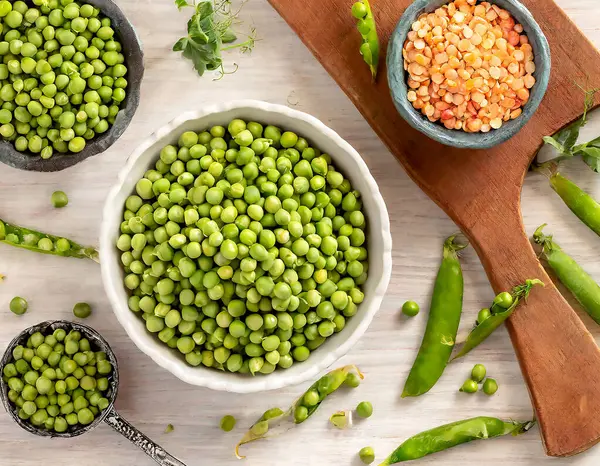 stock image A vibrant and healthful array of fresh green peas showcased in rustic kitchenware, illustrating the appeal of plant-based nutrition.