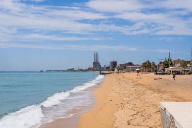 Badalona Sahili 'nde güneşli bir gün, İkonik Enerji Santrali bacalarıyla İspanya