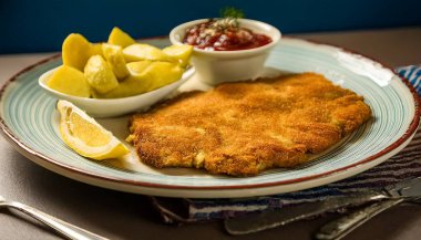 Patates kızartmalı çıtır sosis şnitzel, limonlu don ve Rus soslu sos.