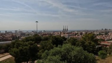 Badalona, İspanya-23 Ağustos 2024. İspanya, Badalona 'daki enerji kulelerinin panoramik görüntüsü, bir doğa parkından. Doğa ve endüstri arasındaki uyum üç bacaya bakan bir parktan elde edildi..