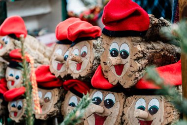 Kırmızı Noel şapkaları takan ve gülümseyen tahta kütükler. Katalan Noel geleneği.